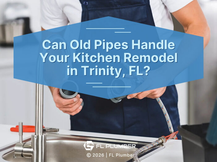 Plumber holding pipe fittings and flexible hose over sink.